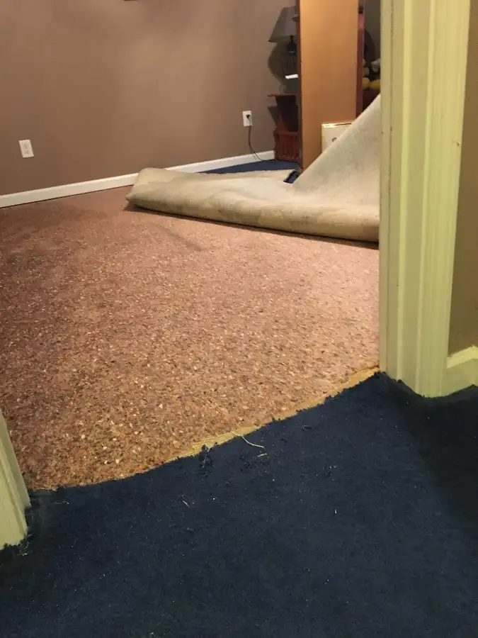Carpet pad removal revealing water damage during Water Mitigation Services in Liberty Hill